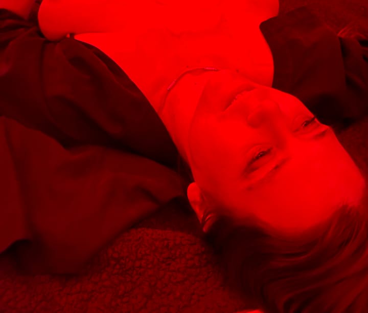 A woman with an open shirt laying on a bed